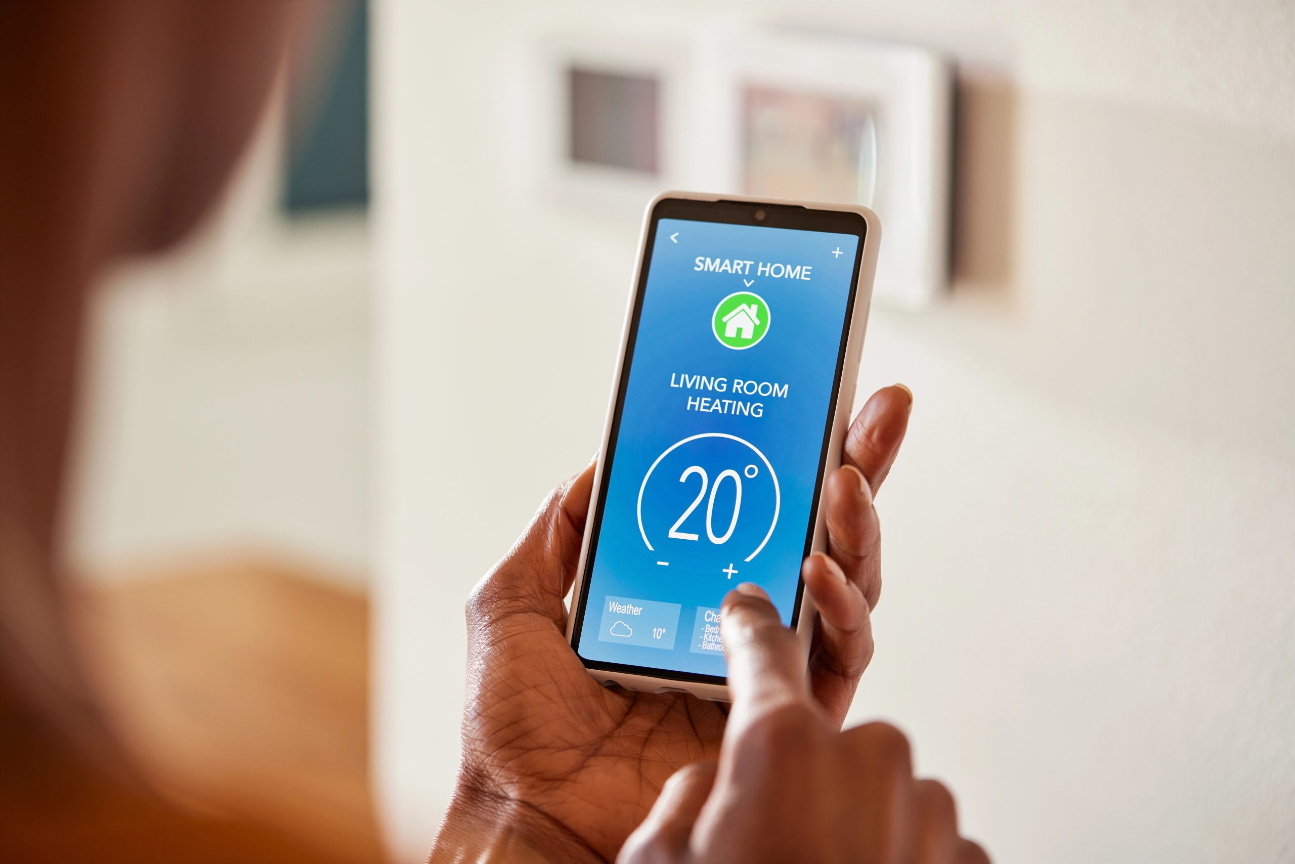 Person using a smartphone app to control lounge heating. Smart heating control.